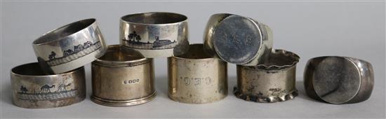 A pair of George V silver signet ring shaped napkin rings and other napkin rings including three silver